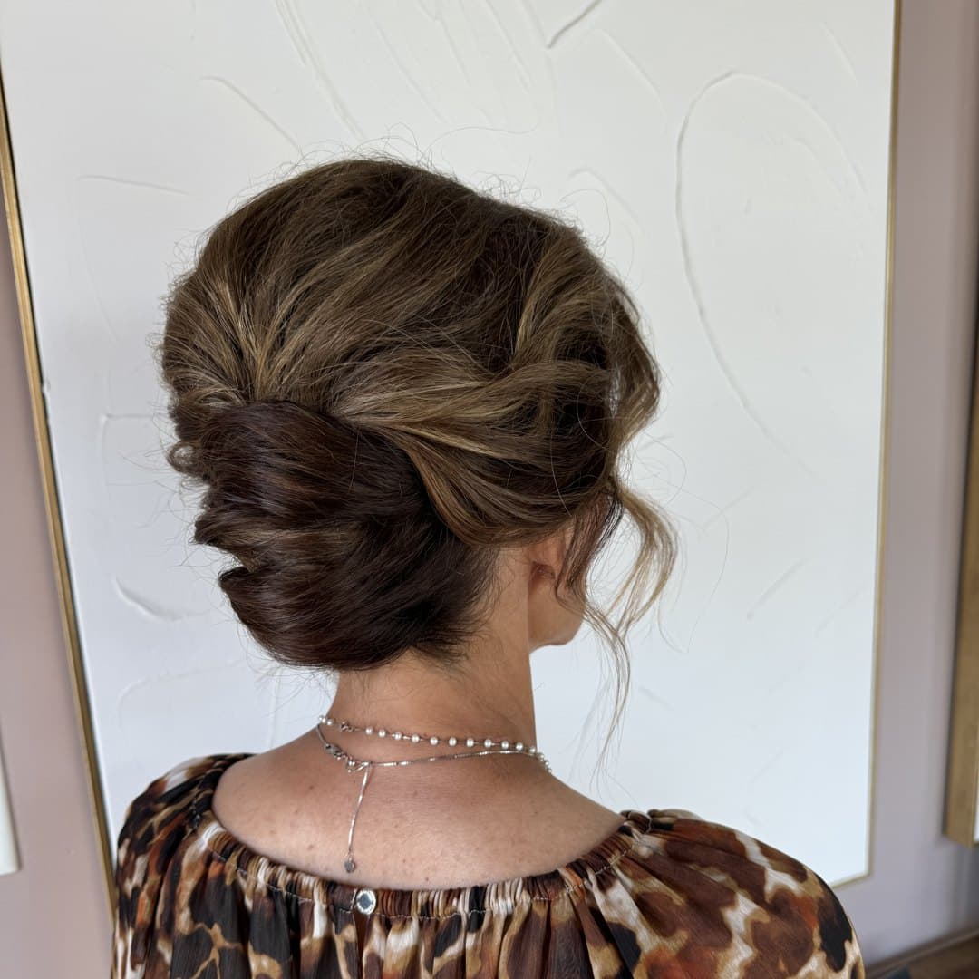 Brunette twisted low updo with tendrils