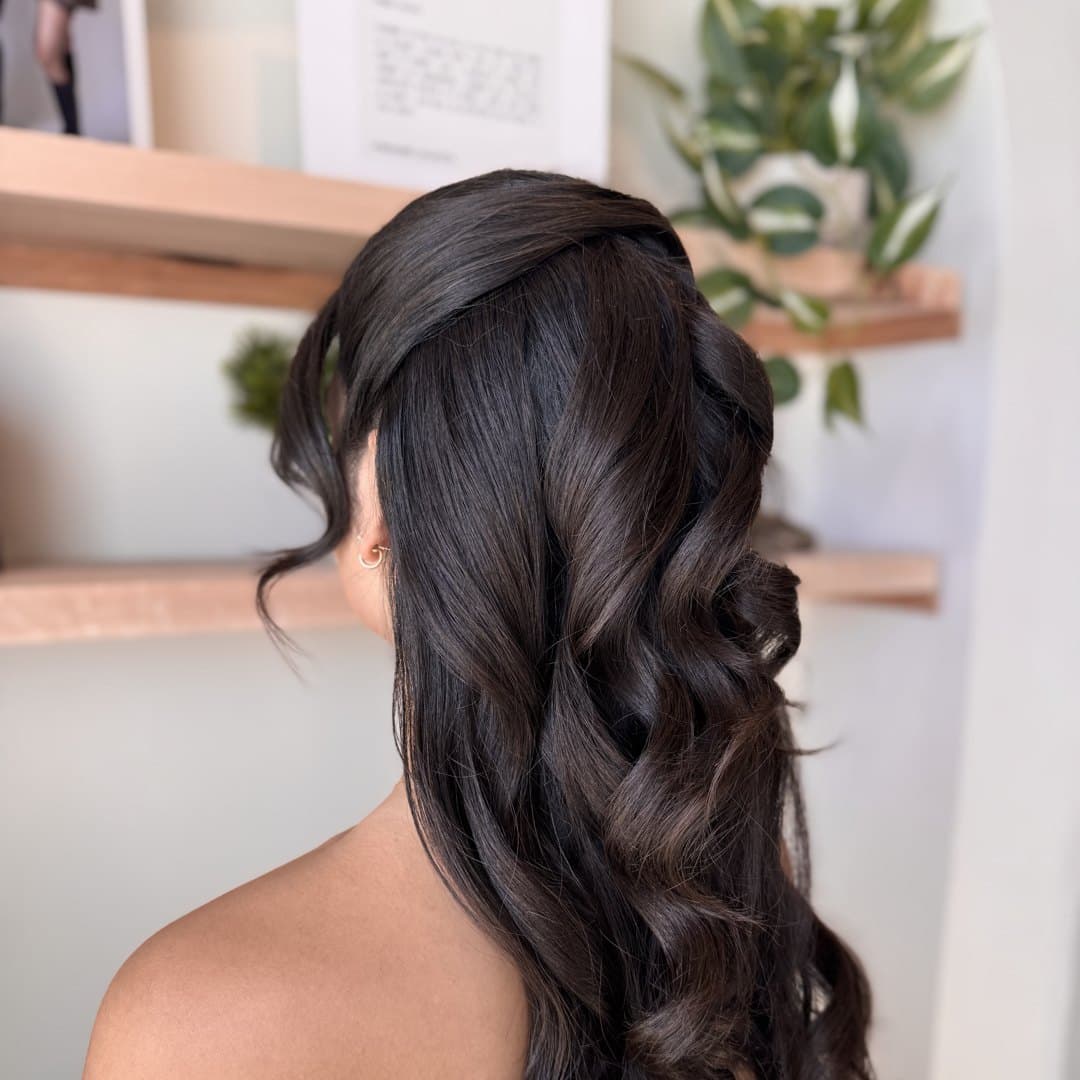 Glossy curls swept over one shoulder